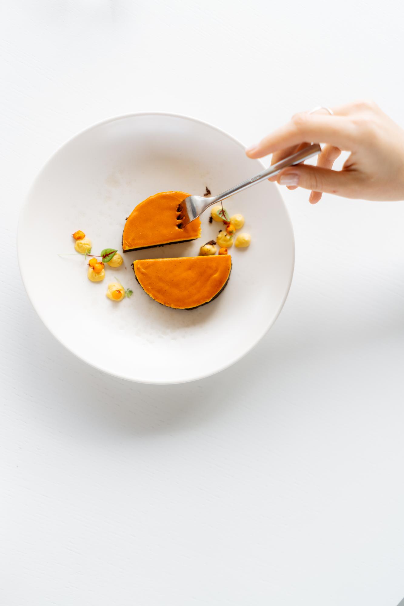 Chef arranging plated seasonal dish on wooden table